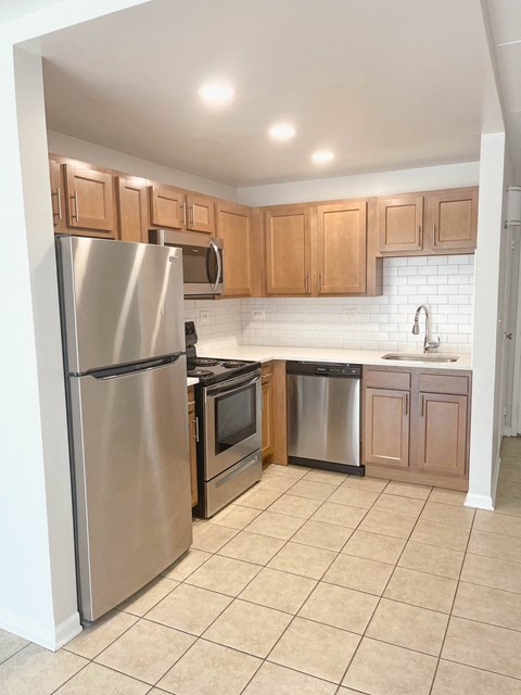 a kitchen with stainless steel appliances and wooden cabinets